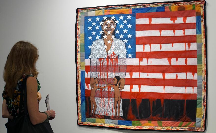 A visitor watches the work of artist Faith Ringgold, "The Flag is Bleeding #2" during a preview on December 4, 2019.