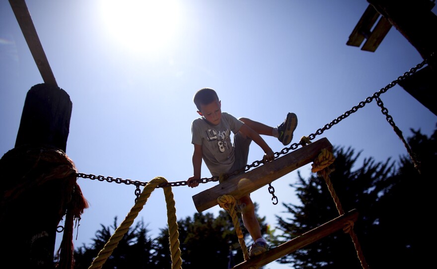 Seven-year-old Tyler Swenson uses a rope and a ladder to climb a wooden structure at the Berkeley Adventure Playground in California.