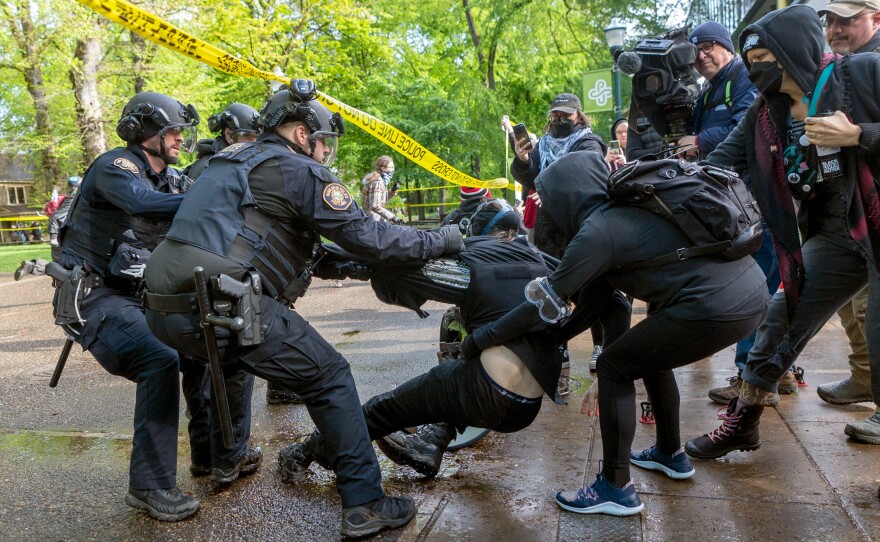 A person who attempted to escape from the library is detained and arrested. Law enforcement teams clear protesters from Portland State University's Branford Price Millar Library on May 2. Demonstrators protesting the war in Gaza have occupied the library since Monday evening.