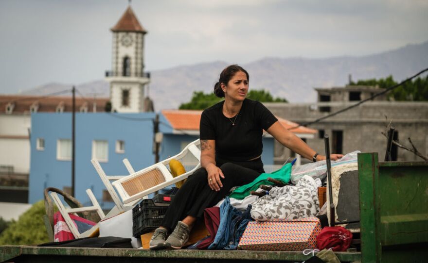 A woman is evacuated to safety with the belongings she could gather, as the Cumbre Vieja volcano on La Palma continues to erupt after two months. It's forced thousands from their homes.
