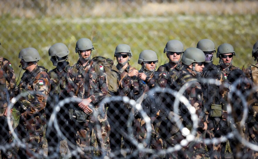 Soldiers stand by the border between Hungary and Serbia.