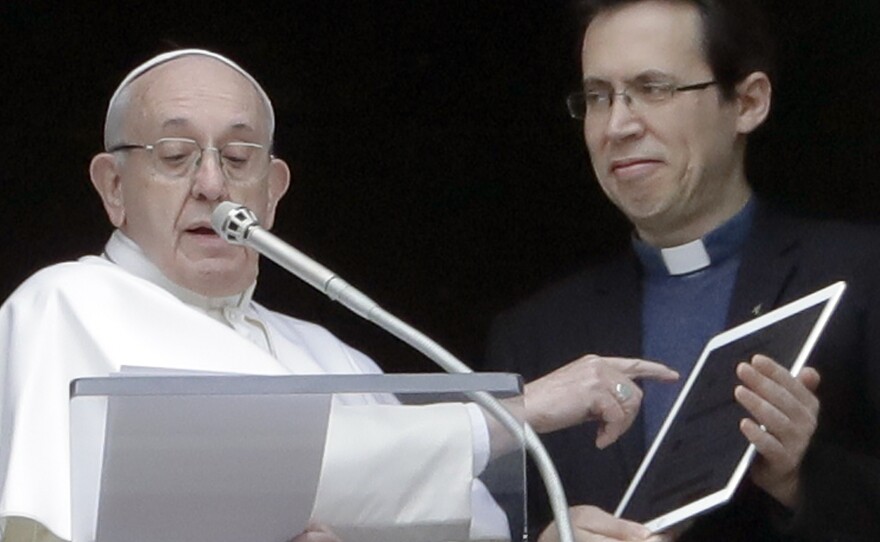 Pope Francis points at a tablet as he unveils Click To Pray, the official app of the Pope's Worldwide Prayer Network on Sunday.