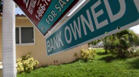 A "bank owned" sign is posted in front  of a foreclosed home in Miami. Borrowers trying to rebuild their lives after foreclosure say there's a stigma attached to having a low credit score.