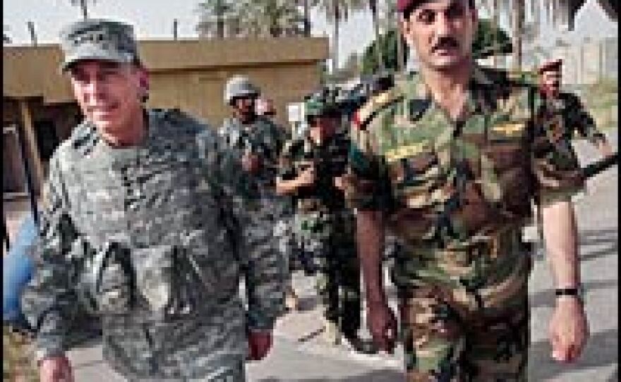 Gen. David Petraeus (left), commander of U.S. military forces in Iraq, walks with an Iraqi colonel during an inspection in the Baghdad area of Kadimiyah, June 27, 2007.