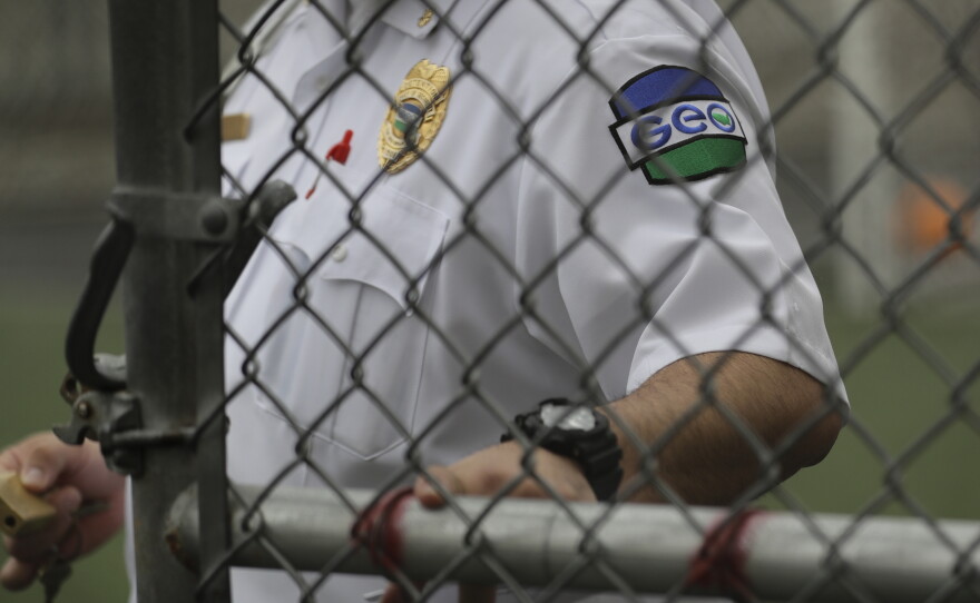 A GEO Group guard closes a door at a U.S. Immigration and Customs Enforcement detention center during a media tour on Dec. 16, 2019, in Tacoma, Wash.