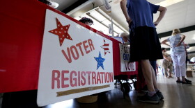 People stand near a voter registration table at a 2022 event in Fredericksburg, Texas.