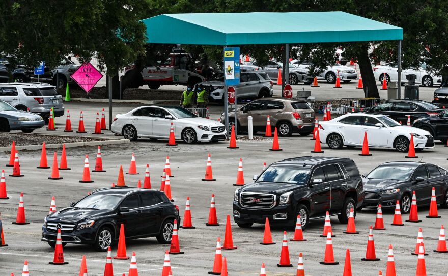 People wait in their vehicles to get vaccinated at a drive-thru site at Hard Rock Stadium in Miami, Florida on April 1. President Biden is expected to announce an April 19 deadline for all states to open eligibility to individuals ages 16 and up.