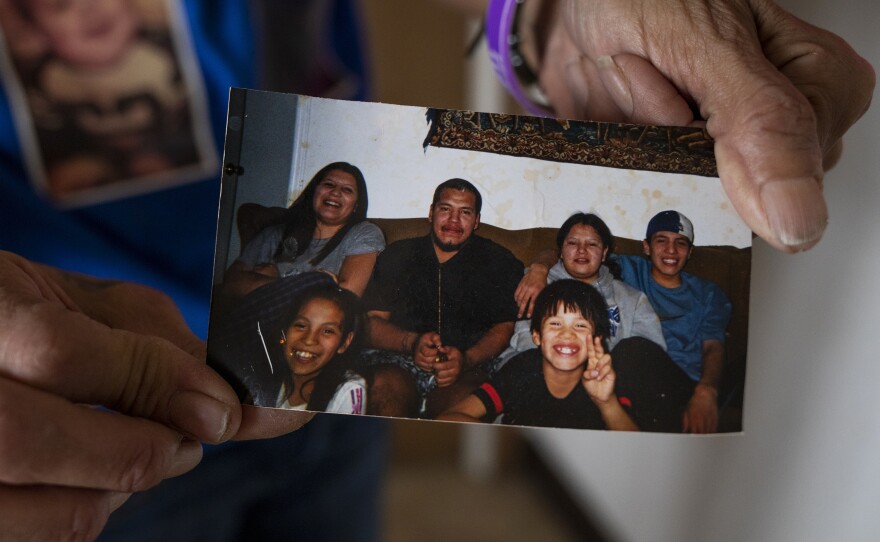 Donna First Raised holds a photo of her six children, including Joe Snell (center). He collapsed while exercising at the jail on the Spirit Lake Tribe Reservation in North Dakota, where he was serving a three-month sentence for a parole violation.