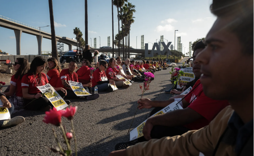 Trabajadores de hoteles y simpatizantes de Unite Here Local 11 se sientan durante una protesta en una de las entradas principales del aeropuerto LAX, el 22 de junio de 2023. Foto de Zaydee Sanchez para CalMatters