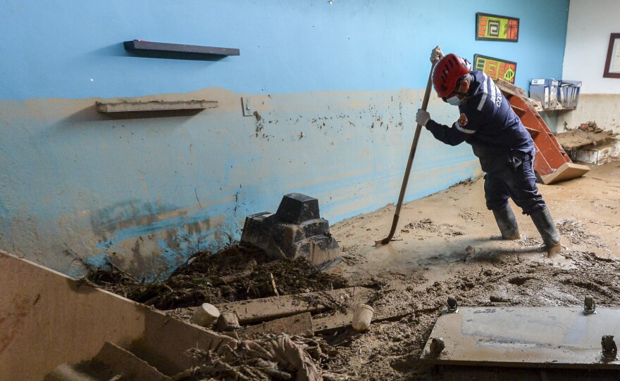 A fireman searches for victims inside a muddy house, following mudslides caused by heavy rains in Mocoa, Putumayo department, southern Colombia, on Sunday. Rescuers are clawing through piles of muck and debris in search of survivors.