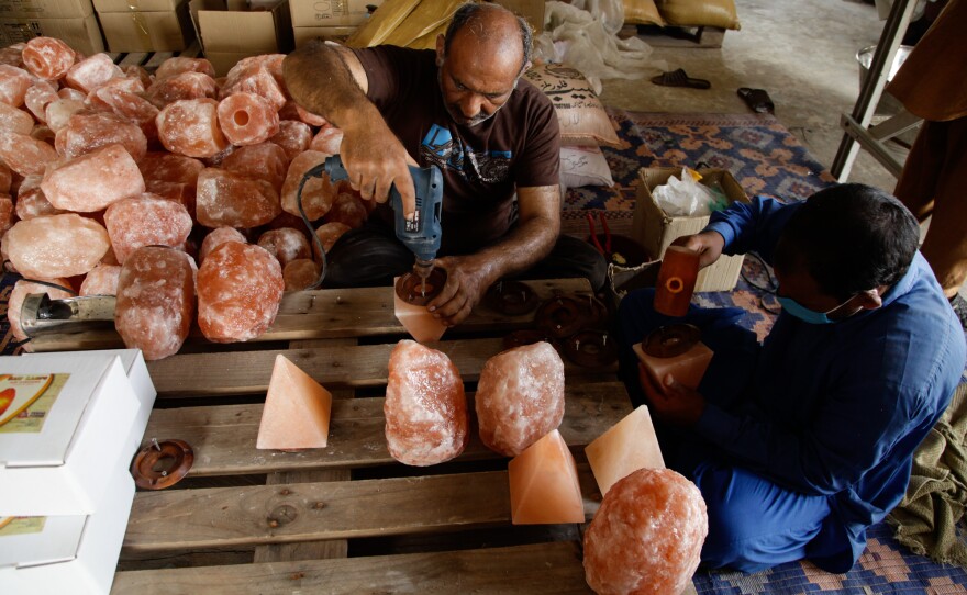 Workers drill wooden bases onto Himalayan salt lamps at a store owned by Niaz Hussain Siddiqui, who exports Pakistani salt products to the United States.