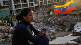 Estefany Landaez sits amid the rubble of a collapsed building in La Guaira, Venezuela, on July 12, 2026, as she waits for news about her two children following the earthquakes.