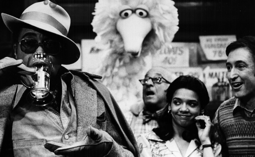 James Earl Jones guest stars on Sesame Street with regular cast members Big Bird, Mr. Hooper (played by actor Will Lee) and Maria (actor Sonia Manzano).