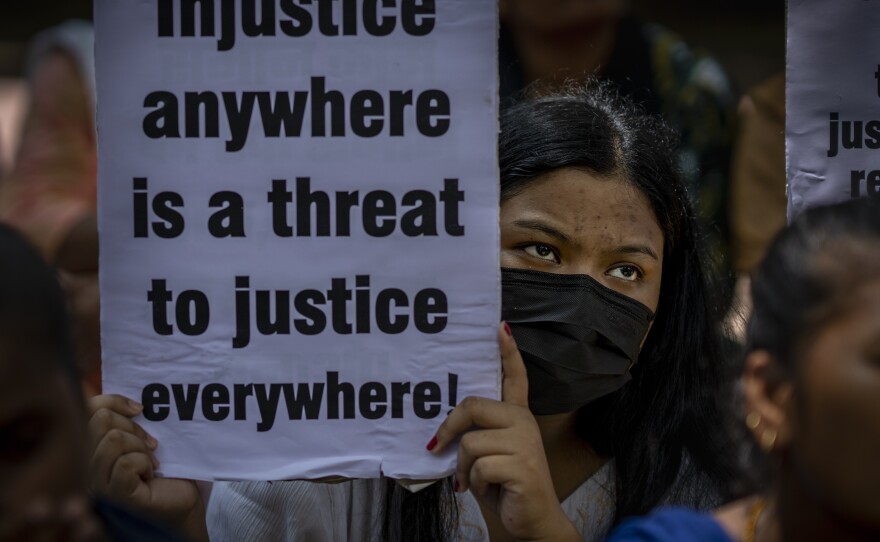 An activist holds a placard during a protest against remission of sentence by the government to convicts of a gang rape, in New Delhi, India, Thursday, Aug. 18, 2022.