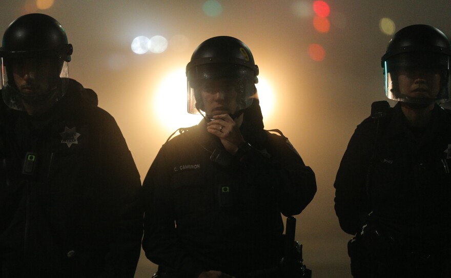 Oakland police officers, wearing body cameras, form a line during demonstrations against recent incidents of alleged police brutality nationwide.