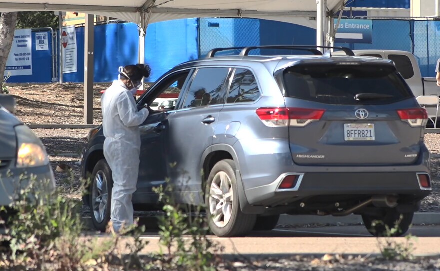 Cars line up for the COVID Clinic in a parking lot at MiraCosta College.
