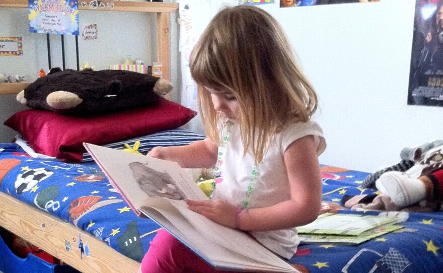 Four-year-old Gabriella Anderson spends her free time reading a hardback book in her brothers' bedroom.  