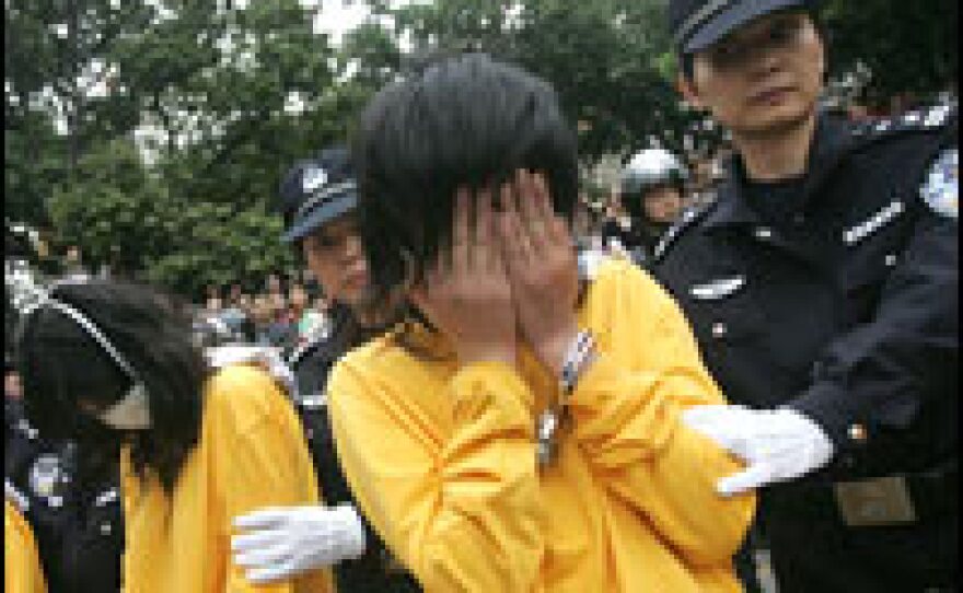 Police put suspected prostitutes, pimps and their clients on display in Shenzhen, China, Nov. 29, 2006. Police read aloud the names, ages and hometowns of the handcuffed men and women.