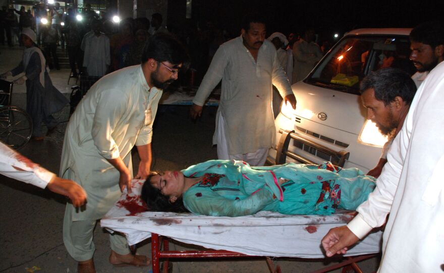 Relatives bring an injured woman to a hospital in Lahore.