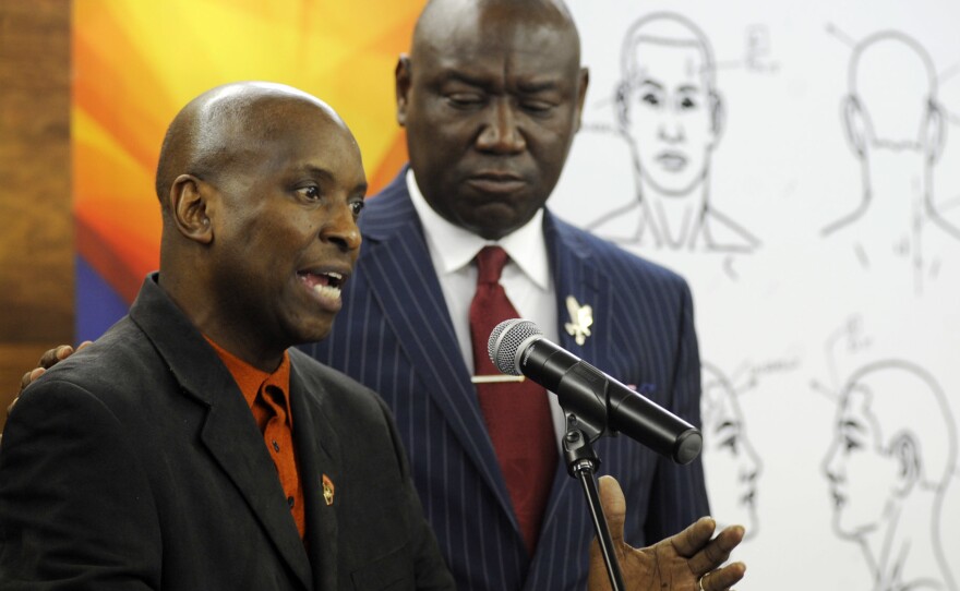 Emantic Bradford Sr. (left) discusses the results of a forensic examination on his son, EJ, who was fatally shot by police on Thanksgiving. Flanked by attorney Ben Crump, the elder Bradford addressed a news conference Monday in Birmingham, Ala.