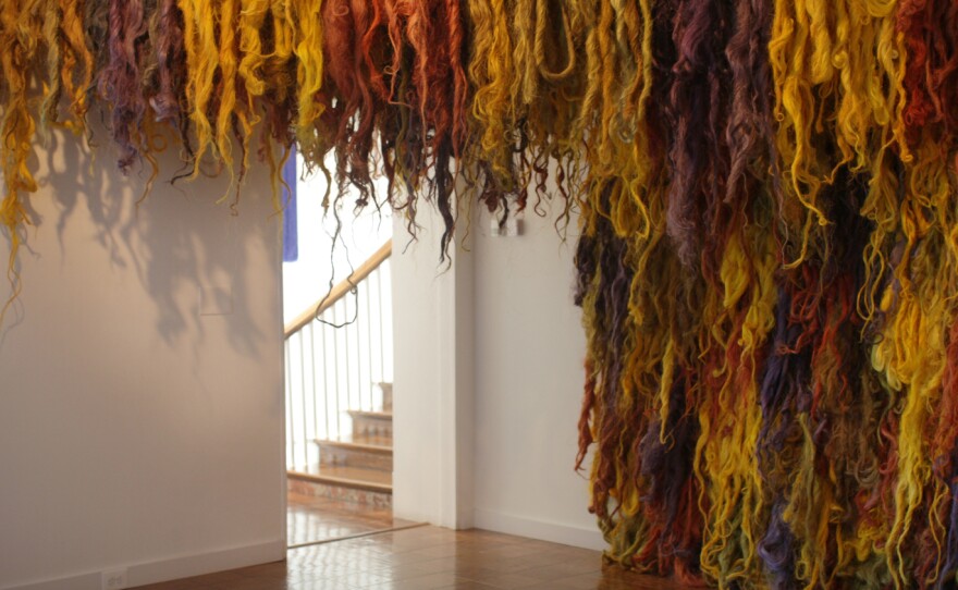 Dyed figue fibers by Susana Mejia hang in the exhibit.