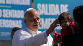 Pope Leo XIV blesses a child during a meeting with migrants at the "Las Raices" center, in San Cristobal de la Laguna in Spain.