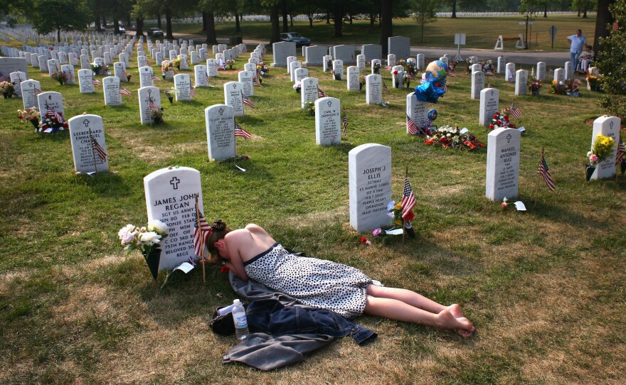 Mary McHugh mourns her slain fiance, Sgt. James Regan, at Arlington National Cemetery in 2007. Regan, a U.S. Army Ranger, was killed by a bomb in Iraq earlier that year. Nearly 7,000 U.S. military personnel have been killed and more than 50,000 wounded in the past 15 years of war.