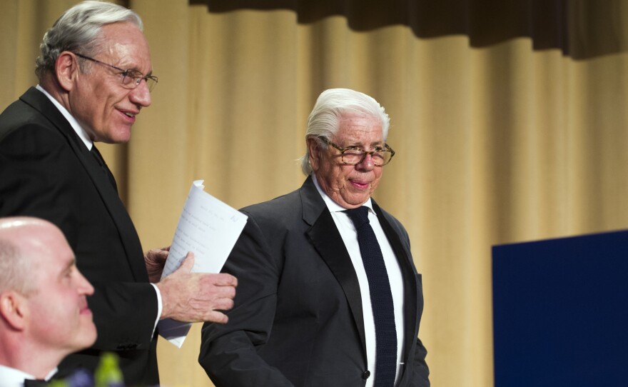 White House Correspondents' Association President Jeff Mason, lower left, looks as on journalists Bob Woodward, left, and Carl Bernstein, approach the podium to address the association's dinner in Washington Saturday.