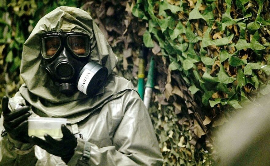 An instructor at Fort Leonard Wood, Mo., carries VX nerve agent inside a special chamber used for training in 2003.