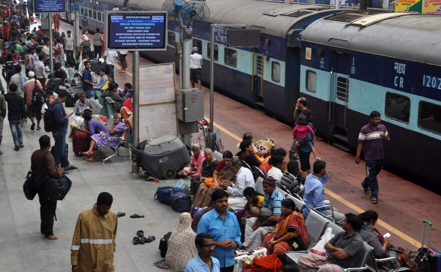 Commuters in Chennai wait at a railway station after most of the city's trains were suspended due to flooding.