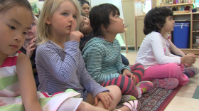 A child at the Mesa Child Development Center puts her finger to her lips as part of a routine to bring students from controlled chaos outside to upright and facing forward inside, April 13, 2017.