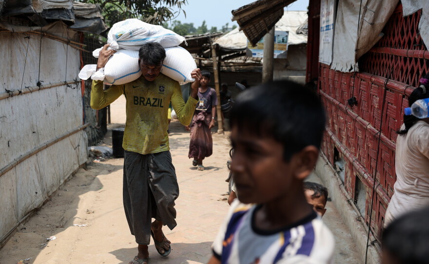 A man carries sacks on his shoulders in a Rohingya refugee camp in Cox's Bazar, Bangladesh, April 21, 2026.