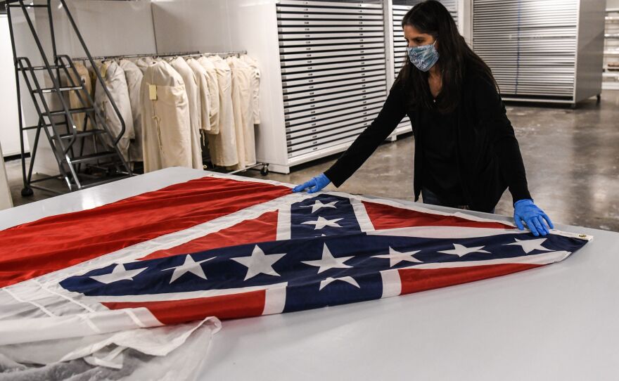 Director of Collections Nan Prince pulls out the Mississippi flag from the state's capitol on Sept. 25, 2020. The flag, the last state banner to feature a Confederate emblem, was permanently retired after Gov. Tate Reeves signed a bill ordering the flag's removal.