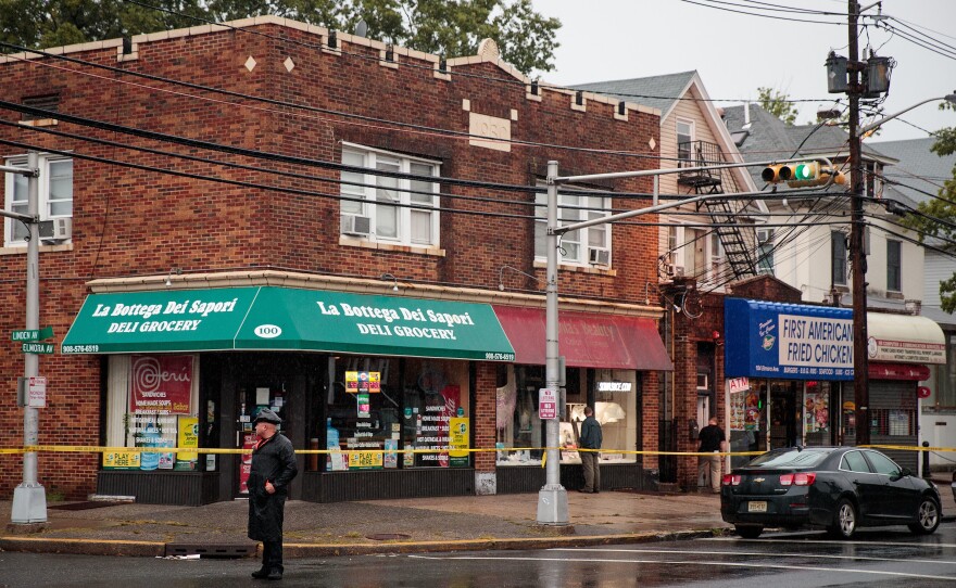 A local police officer stands guard at an intersection as members of the FBI and other law enforcement agencies investigate a residence near the Rahami family's restaurant, First American Fried Chicken, in Elizabeth, N.J., on Monday.