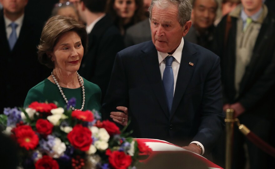 Former U.S. President George W. Bush and his wife Laura Bush pay their respects in front of the casket of the late former President George H.W. Bush as he lies in state in the U.S. Capitol Rotunda, Tuesday in Washington, D.C.