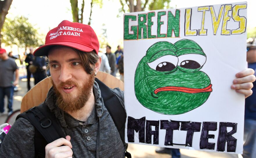 Andrew Knight holds a sign of Pepe the frog, an alt-right icon, during a rally in Berkeley, Calif., on April 27.