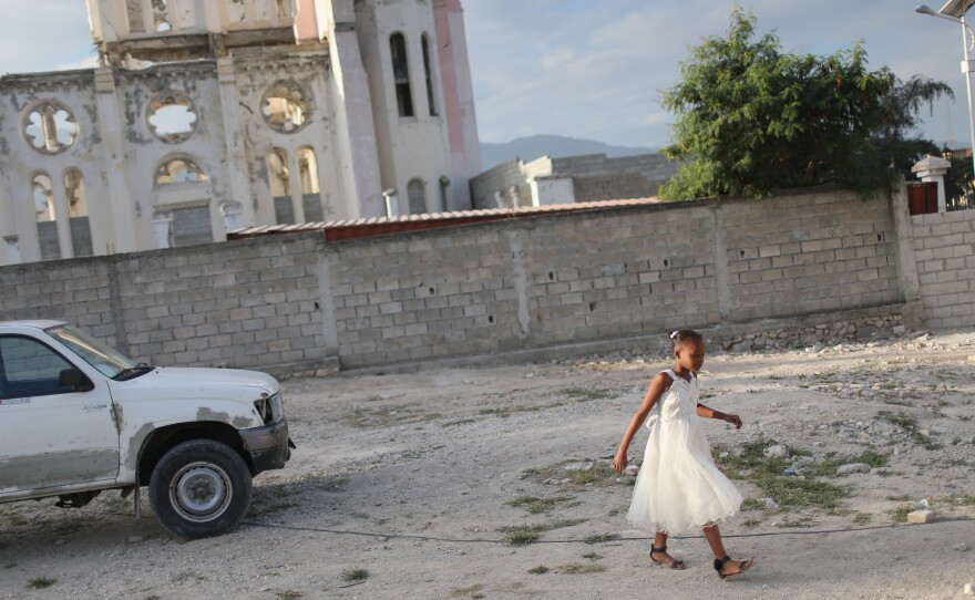A child walks near the ruins of the National Cathedral in Port-au-Prince on Sunday. After the 2010 earthquake destroyed the cathedral, a new church was built next to the ruins.