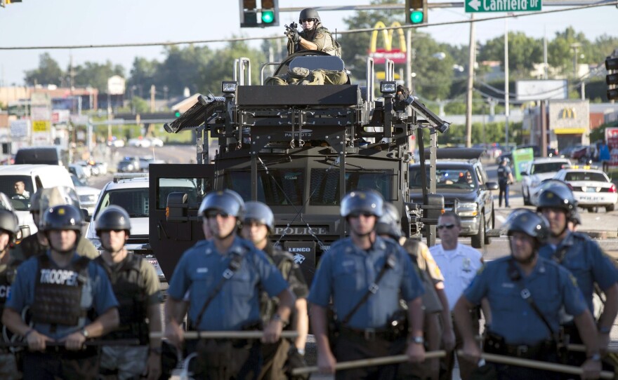 Riot police stand guard as demonstrators protest the shooting death of teenager Michael Brown in Ferguson, Mo., Wednesday. The police have been an increasingly militarized presence as the protests continued this week.