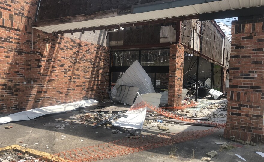 A grocery storefront blown out by Hurricane Ida last year stands abandoned in a Houma, La., strip center.