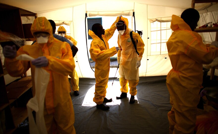 At the care center, volunteers don protective gear before entering the compound where patients are held.