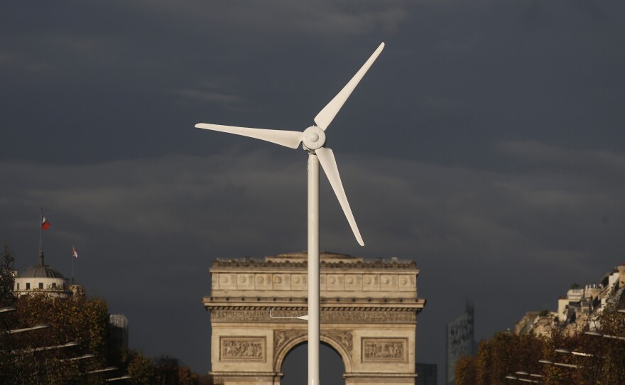 A power-generating windmill turbine is seen in front of the Arc de Triomphe on the Champs Elysees avenue in Paris ahead of the COP21 World Climate Summit, which begins Monday.