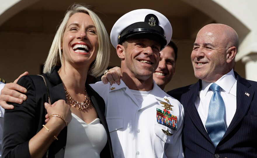 Navy Special Operations Chief Edward Gallagher, center, walks with his wife, Andrea Gallagher, left, and advisor, Bernard Kerik as they leave a military court on Naval Base San Diego, Tuesday, July 2, 2019, in San Diego. A military jury acquitted the decorated Navy SEAL Tuesday of murder in the killing of a wounded Islamic State captive under his care in Iraq in 2017.