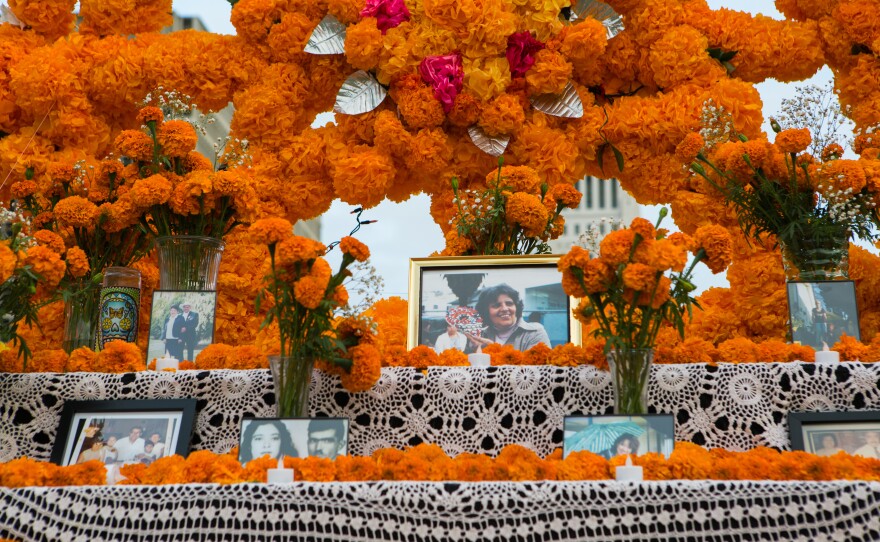 <em>Altarista </em>Ofelia Esparza says it's been "a nightmare year" of loss for her family. Above, framed photographs of loved ones lost at her community altar in Grand Park.