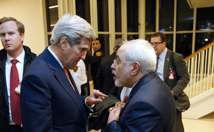 U.S. Secretary of State John Kerry (left) speaks with Iranian Foreign Minister Mohammad Javad Zarif after the IAEA verified that Iran has met all conditions under the nuclear deal.