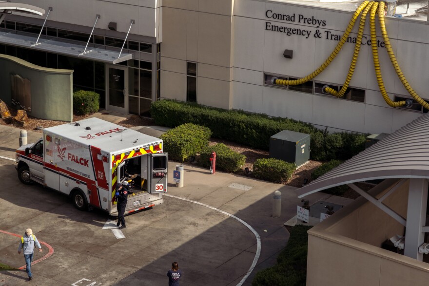 A paramedic waits with a patient in his ambulance outside the Conrad Prebys Emergency Room at Scripps Mercy Hospital in the Hillcrest neighborhood of San Diego at around 10:30 a.m. on Friday January 7, 2022.