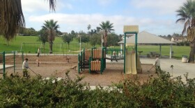 Chula Vista Parks & Recreation Department employees search for razor blades in Harvest Park, July 24, 2015. 