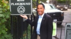 Councilman Todd Gloria stands next to a sign recognizing a private donation in New York City's Central Park. Gloria said similar sponsorships could be used in Balboa Park.