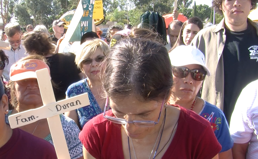 Audience members watch the unveiling of a memorial wall at a San Ysidro church, September 20, 2015. 