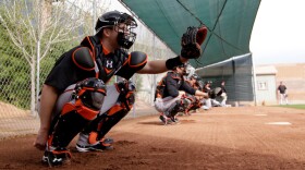 Catcher Buster Posey, seen here during a spring training workout Sunday, has been told by the San Francisco Giants that he should avoid blocking home plate. Posey broke his leg on a scoring play at the plate last season.