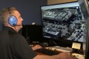 A man wearing headphones controls a Chula Vista Police Department drone from a computer while sitting at a desk, Feb 5. 2020.